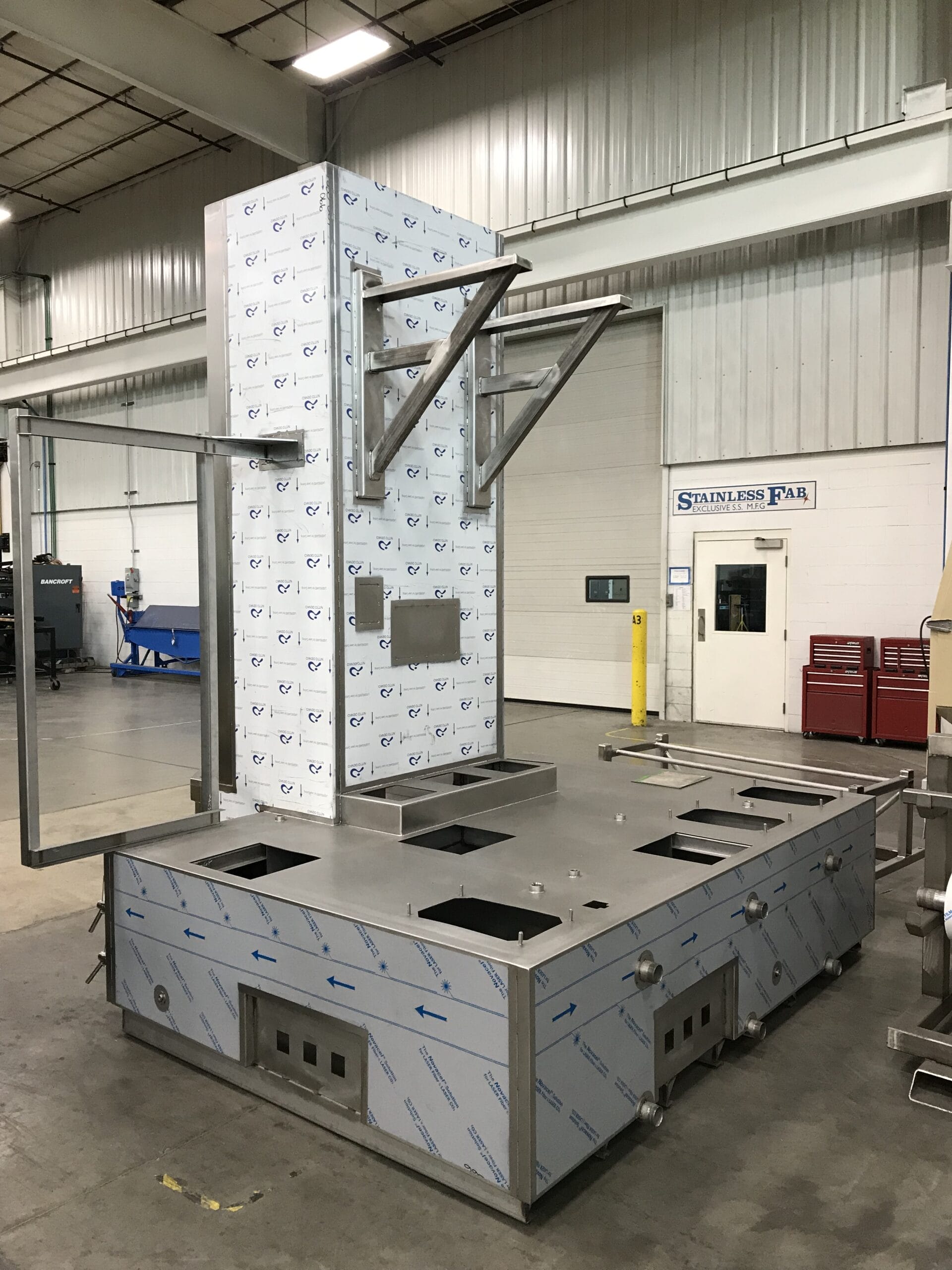Upright stainless parts washer with integrated containment.