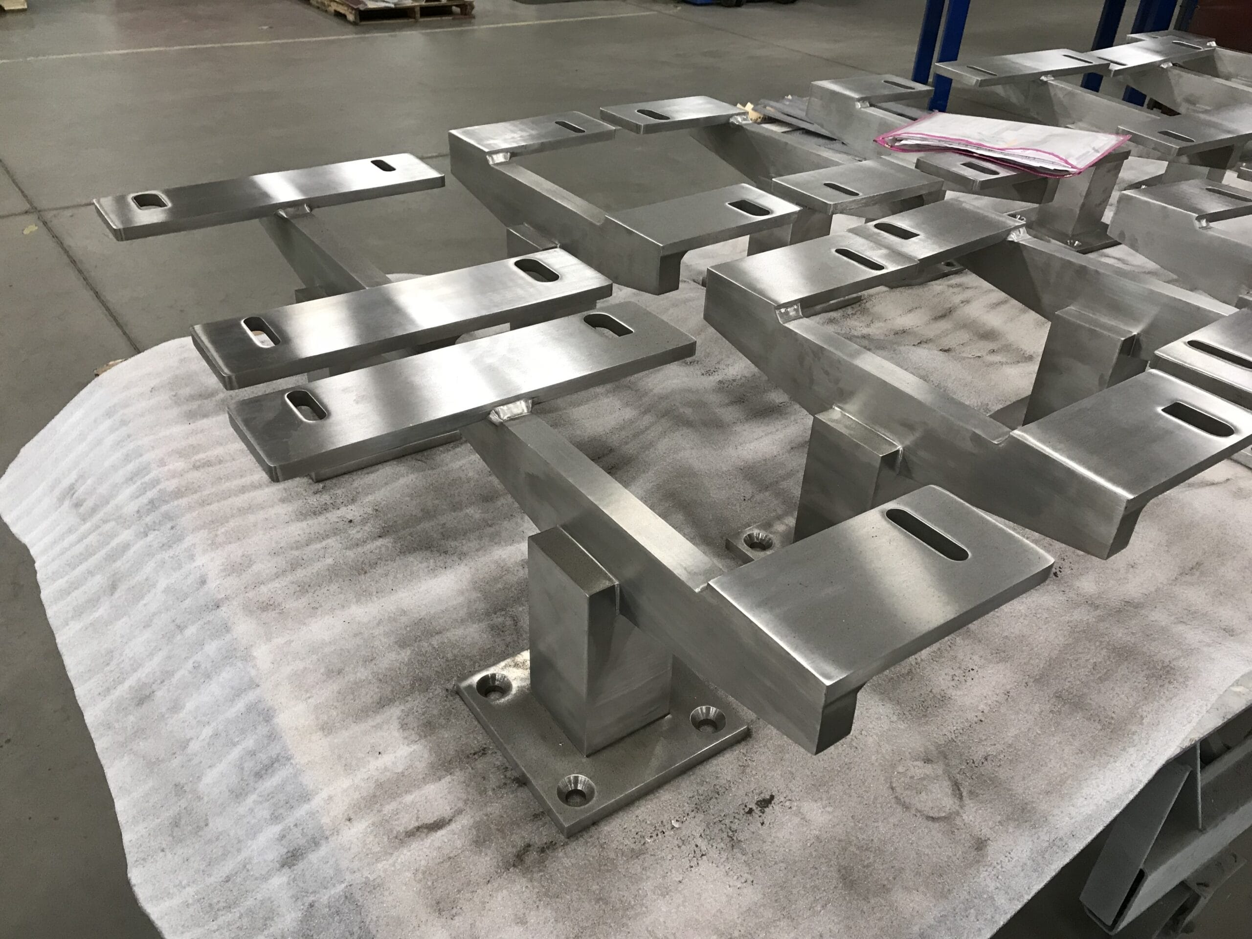 Architectural stainless glass façade components; welded, ground, and polished smooth.
