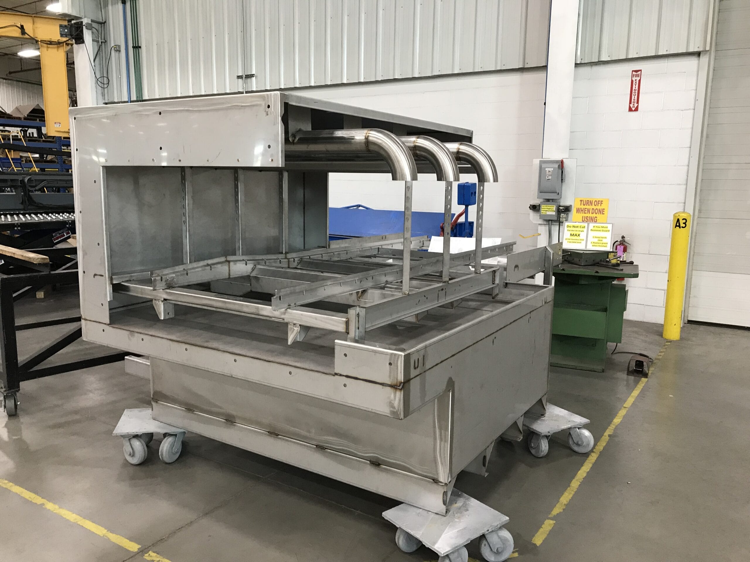 Stainless parts washer assembly with formed panels and welded seams.