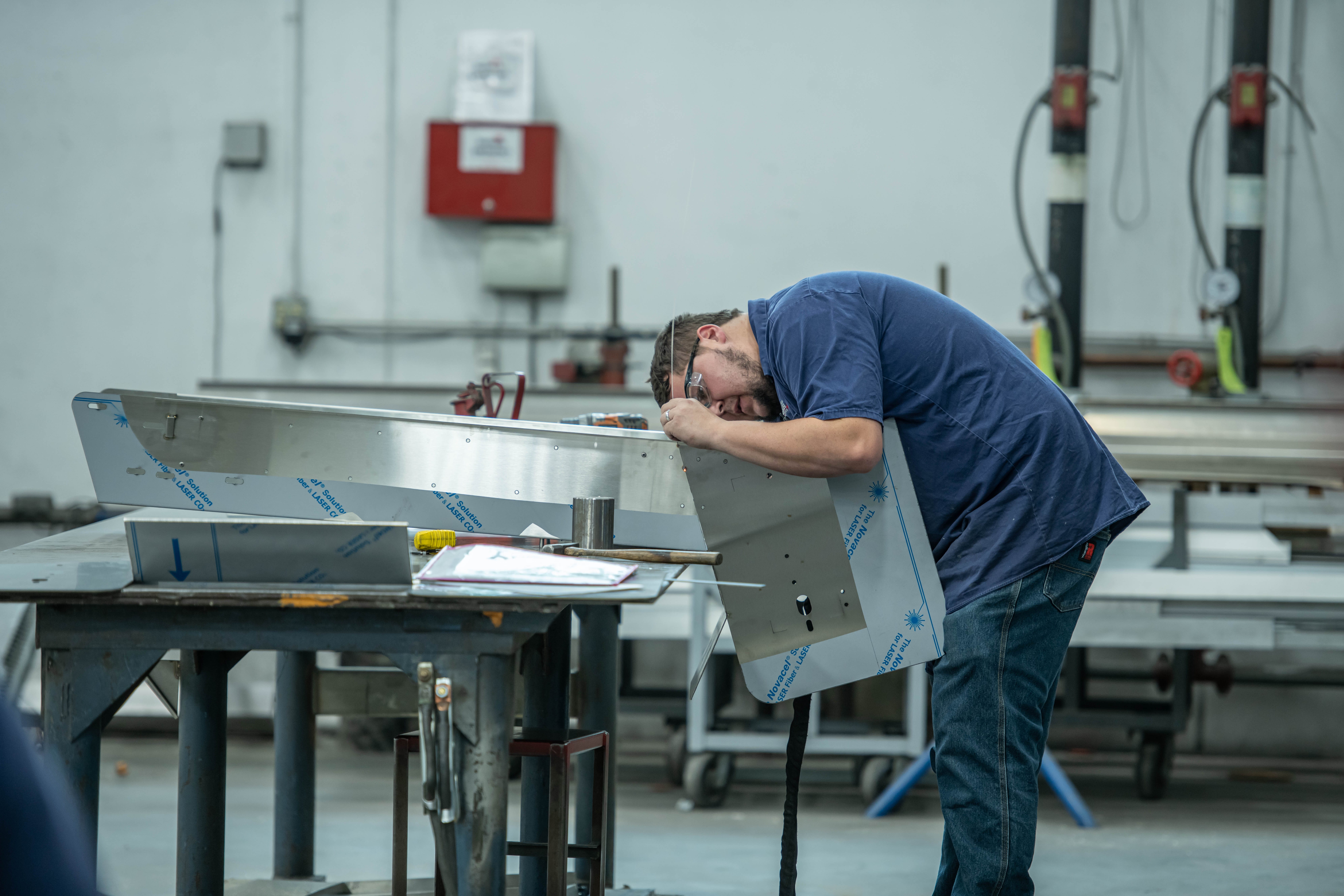 Fabricator fitting and aligning stainless panel assembly prior to welding.